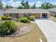 Charming single-story home featuring a well-manicured lawn, mature trees and concrete driveway at 218 Parkview Dr, Venice, FL 34293