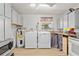 Bright laundry room includes washer, dryer, utility sink, storage cabinets, and a microwave oven at 218 Parkview Dr, Venice, FL 34293
