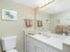 Bathroom with white cabinets, neutral counter tops, and a decorative mirror at 22375 Edgewater Dr # 128, Port Charlotte, FL 33980