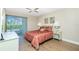 Bedroom featuring a double bed with red floral bedding and sliding doors to the outside at 22375 Edgewater Dr # 128, Port Charlotte, FL 33980