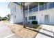 Close-up of a pristine white condo exterior featuring a well-kept lawn and a small palm tree at 22375 Edgewater Dr # 128, Port Charlotte, FL 33980