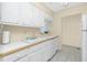 Bright kitchen showcasing white cabinets, countertops, and modern appliances, with a double basin sink at 22375 Edgewater Dr # 128, Port Charlotte, FL 33980