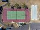 Aerial view of community tennis court with vibrant green and red surface, well-maintained at 22375 Edgewater Dr # 128, Port Charlotte, FL 33980