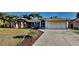 Charming single-story home with a well-manicured lawn, palm trees, and a spacious driveway at 23344 Van Buren Ave, Punta Gorda, FL 33980