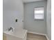 Functional laundry room with a utility sink, window, and minimalist design at 23344 Van Buren Ave, Punta Gorda, FL 33980