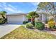 Inviting single-story home featuring a lush lawn, a two-car garage, and tropical landscaping at 24317 Kintail Ct, Punta Gorda, FL 33980