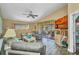 Bright living room featuring vaulted ceilings, ceiling fan and sliding glass doors to a screened lanai at 24317 Kintail Ct, Punta Gorda, FL 33980