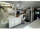Bright kitchen with breakfast bar, white cabinets, stainless refrigerator, and tile floors at 25188 Marion Ave # 1004, Punta Gorda, FL 33950