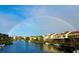 Beautiful waterfront homes with private docks on a sunny day, enhanced by a colorful rainbow at 25188 Marion Ave # 1004, Punta Gorda, FL 33950