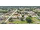 Aerial view of a residential neighborhood with a beige two-story home featuring a spacious backyard and mature trees at 26100 Paysandu Dr, Punta Gorda, FL 33983