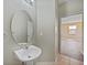 Bathroom featuring a pedestal sink, oval mirror and doorway leading to another room at 26100 Paysandu Dr, Punta Gorda, FL 33983