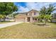 Charming two-story home with attached garage, manicured lawn, and palm trees at 26100 Paysandu Dr, Punta Gorda, FL 33983