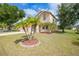 Charming two-story home with attached garage, manicured lawn, and palm trees at 26100 Paysandu Dr, Punta Gorda, FL 33983
