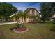 Inviting two-story home with a well-manicured lawn and palm tree landscaping at 26100 Paysandu Dr, Punta Gorda, FL 33983