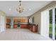Open kitchen with stainless steel appliances, tiled floor, and brown cabinets at 26100 Paysandu Dr, Punta Gorda, FL 33983