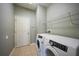 Bright laundry room with tiled floors, washer, dryer, white shelving and a door at 26100 Paysandu Dr, Punta Gorda, FL 33983