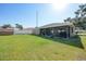 Backyard with lawn, shed, and screened in patio, along with a view of the neighbor's house at 2751 S Cranberry Blvd, North Port, FL 34286