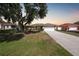 A single story home with a mature tree in the front yard along with a long driveway at 2751 S Cranberry Blvd, North Port, FL 34286