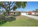 Charming single-story home with a well-maintained lawn and a large shade tree in a sunny neighborhood at 2751 S Cranberry Blvd, North Port, FL 34286