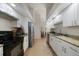 Well-lit kitchen with white cabinets, granite countertops, and stainless steel appliances for modern functionality at 2751 S Cranberry Blvd, North Port, FL 34286