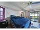 Serene bedroom with wood-look floors, natural light, and a sliding glass door for easy outdoor access at 2751 S Cranberry Blvd, North Port, FL 34286