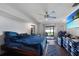 Comfortable bedroom featuring a ceiling fan, sliding glass door to the backyard, and wood-look floors at 2751 S Cranberry Blvd, North Port, FL 34286