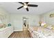Inviting bedroom with wood floors, ceiling fan, and beach themed decor with access to bathroom at 318 Spring Lake Nw Blvd, Port Charlotte, FL 33952
