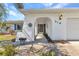 Welcoming front entrance featuring a textured archway, well-maintained landscaping, and stylish exterior lighting at 318 Spring Lake Nw Blvd, Port Charlotte, FL 33952