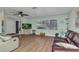 Cozy living room featuring light green walls, wood floors, a ceiling fan, and comfortable seating at 318 Spring Lake Nw Blvd, Port Charlotte, FL 33952