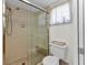 Walk-in shower with glass door, toilet and built-in shower caddy at 318 Spring Lake Nw Blvd, Port Charlotte, FL 33952
