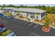 Exterior view of a two-story condo building, manicured landscaping, and a spacious parking area at 3310 Loveland Blvd # 1503, Punta Gorda, FL 33980