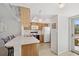 Bright kitchen featuring a breakfast bar, a ceiling fan and modern white appliances at 3310 Loveland Blvd # 1503, Punta Gorda, FL 33980