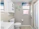 Clean bathroom with a large window, a sink, a toilet, and a shower-tub combo at 3319 Shamrock Dr, Venice, FL 34293