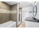Modern bathroom featuring a tub and shower, a stylish vanity, and gray tiling at 3319 Shamrock Dr, Venice, FL 34293
