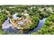 Stunning aerial view of a waterfront home featuring a screened pool, lush landscaping, and private dock at 3400 Allapatchee Dr, Punta Gorda, FL 33950