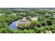 Expansive aerial view shows a canal-front home featuring a screened lanai, mature trees, and a private dock at 3400 Allapatchee Dr, Punta Gorda, FL 33950