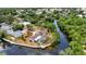 Breathtaking aerial of a waterfront property featuring a screened pool, dock, and meticulously maintained grounds at 3400 Allapatchee Dr, Punta Gorda, FL 33950