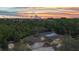 Aerial view of a beautiful home with a screened pool, surrounded by lush green landscape under a gorgeous sunset at 3400 Allapatchee Dr, Punta Gorda, FL 33950