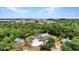 Scenic aerial view of waterfront home surrounded by lush greenery with a screened pool at 3400 Allapatchee Dr, Punta Gorda, FL 33950