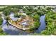 Drone shot displays a desirable waterfront residence with a screened pool, lovely landscaping, and dock at 3400 Allapatchee Dr, Punta Gorda, FL 33950
