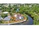 Waterfront property on canal surrounded by lush trees, and well-maintained landscaping at 3400 Allapatchee Dr, Punta Gorda, FL 33950
