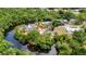 Uncommon aerial view shows a canal-front home featuring a screened lanai, trees, and a private dock at 3400 Allapatchee Dr, Punta Gorda, FL 33950