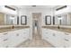 En-suite bathroom with dual sinks, white cabinets, granite counters, and tile floors at 3400 Allapatchee Dr, Punta Gorda, FL 33950