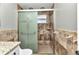 Bathroom with a glass enclosed shower featuring decorative tiles and a built-in soap holder at 3400 Allapatchee Dr, Punta Gorda, FL 33950