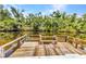 Wooden boat dock overlooking the serene canal, surrounded by lush greenery and trees at 3400 Allapatchee Dr, Punta Gorda, FL 33950