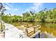 Picturesque wooden dock on the water surrounded by lush greenery under a blue sky at 3400 Allapatchee Dr, Punta Gorda, FL 33950