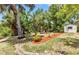 Backyard fire pit area with seating, set amongst lush greenery and mature trees, offers a tranquil outdoor space at 3400 Allapatchee Dr, Punta Gorda, FL 33950