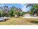 Scenic front yard with lush tropical landscaping, mature trees, and boat parking at 3400 Allapatchee Dr, Punta Gorda, FL 33950