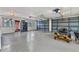 Spacious three-car garage with ample lighting, epoxy flooring, and a refrigerator at 3400 Allapatchee Dr, Punta Gorda, FL 33950