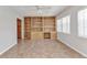 Cozy living room featuring built-in shelving and ample natural light from large windows at 3400 Allapatchee Dr, Punta Gorda, FL 33950